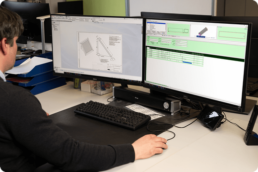 PB Luft + Metall CAD Bauteilbearbeitung ein männlicher Mitarbeiter der Firma PB Luft und Metall Bauteile sitzt vor 2 Monitoren und arbeitet mit einem CAD-Programm